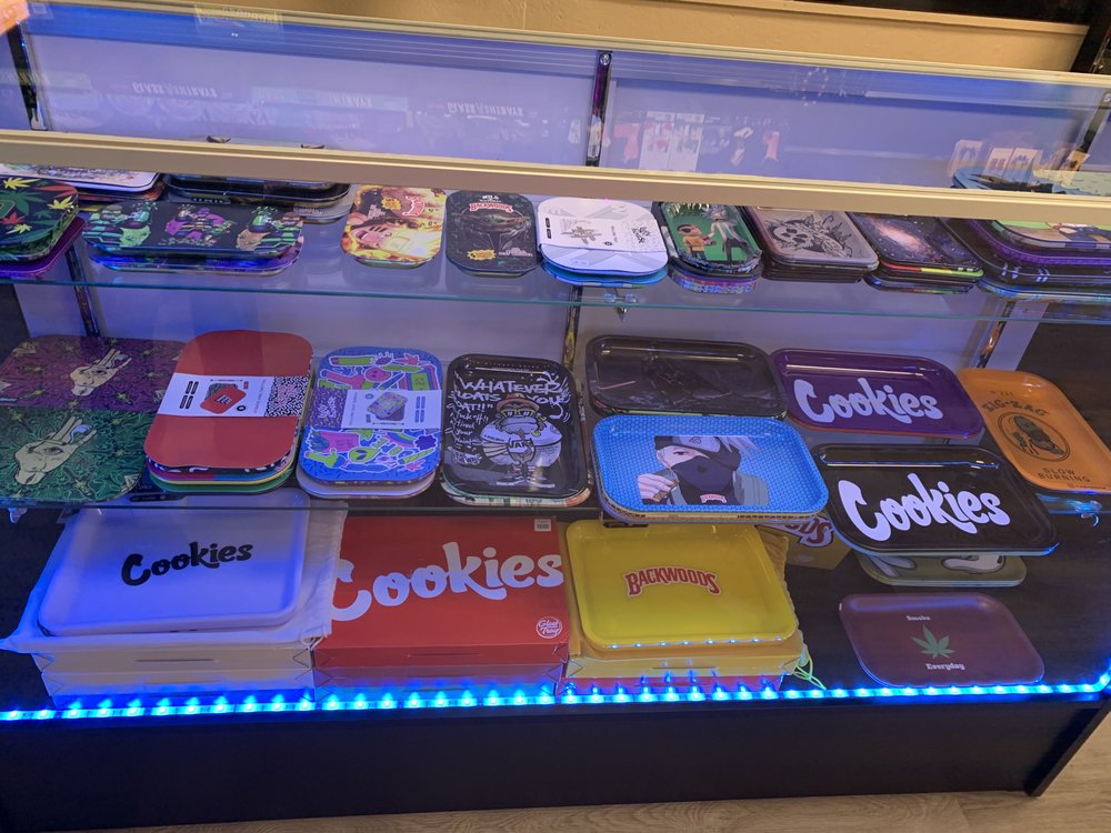 Accessory display with rolling trays and small smoke shop items.
